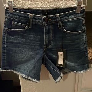 Dark blue cutoff stretch denim shorts with a 4” inseam.